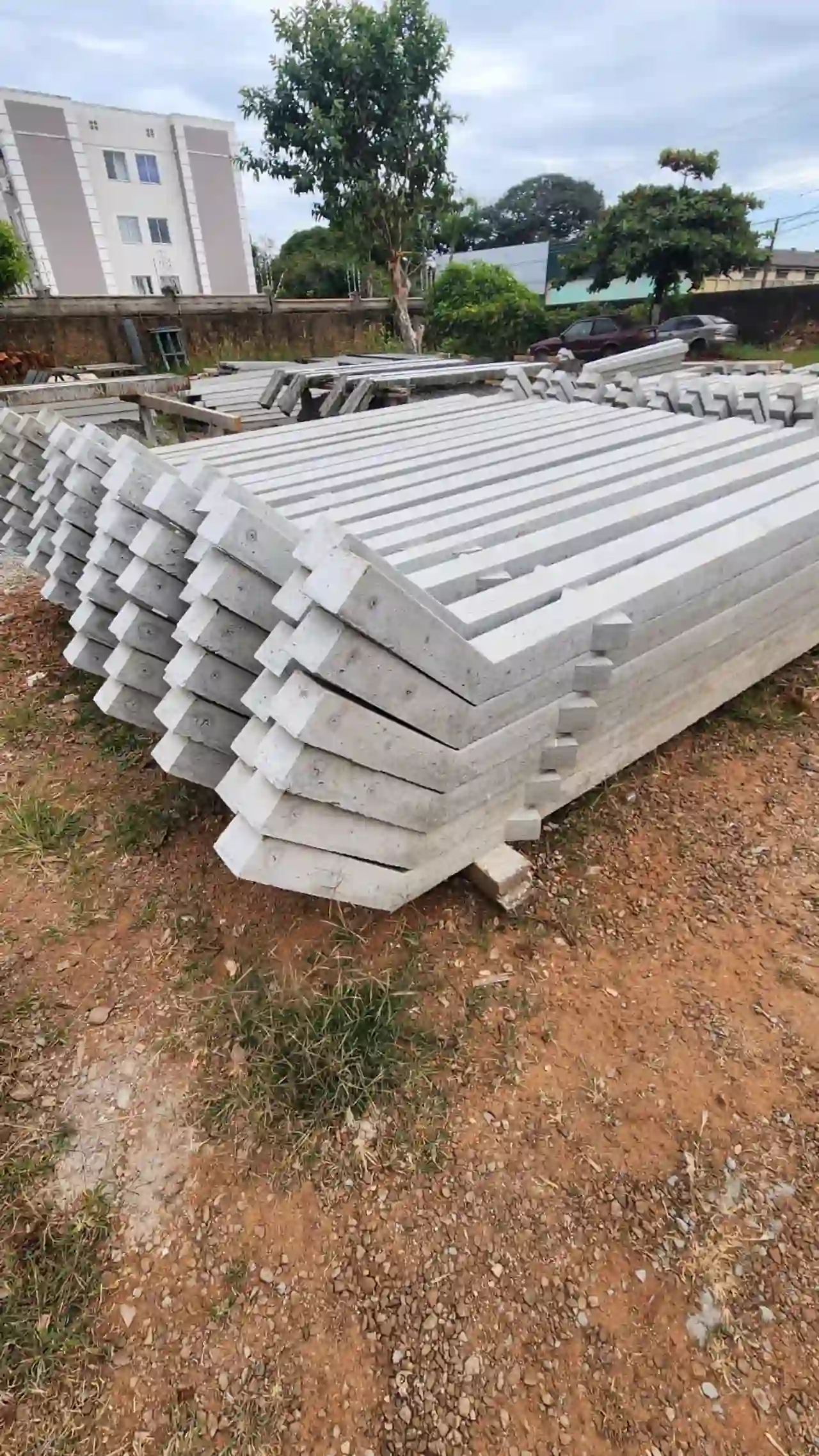 Mourões de concreto angulares empilhados no pátio